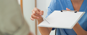 dental hygienist pointing at a clipboard